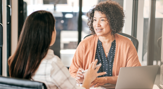 Positive workplace: A manager and a staff member sitting down together in an office space for a productive discussion